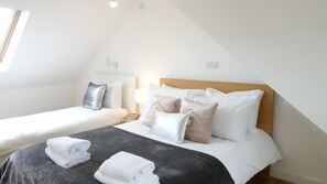 Une chambre à coucher avec un lit, deux tables de chevet et une lampe.
