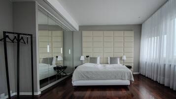Un dormitorio moderno con una cama grande, un espejo y un armario.