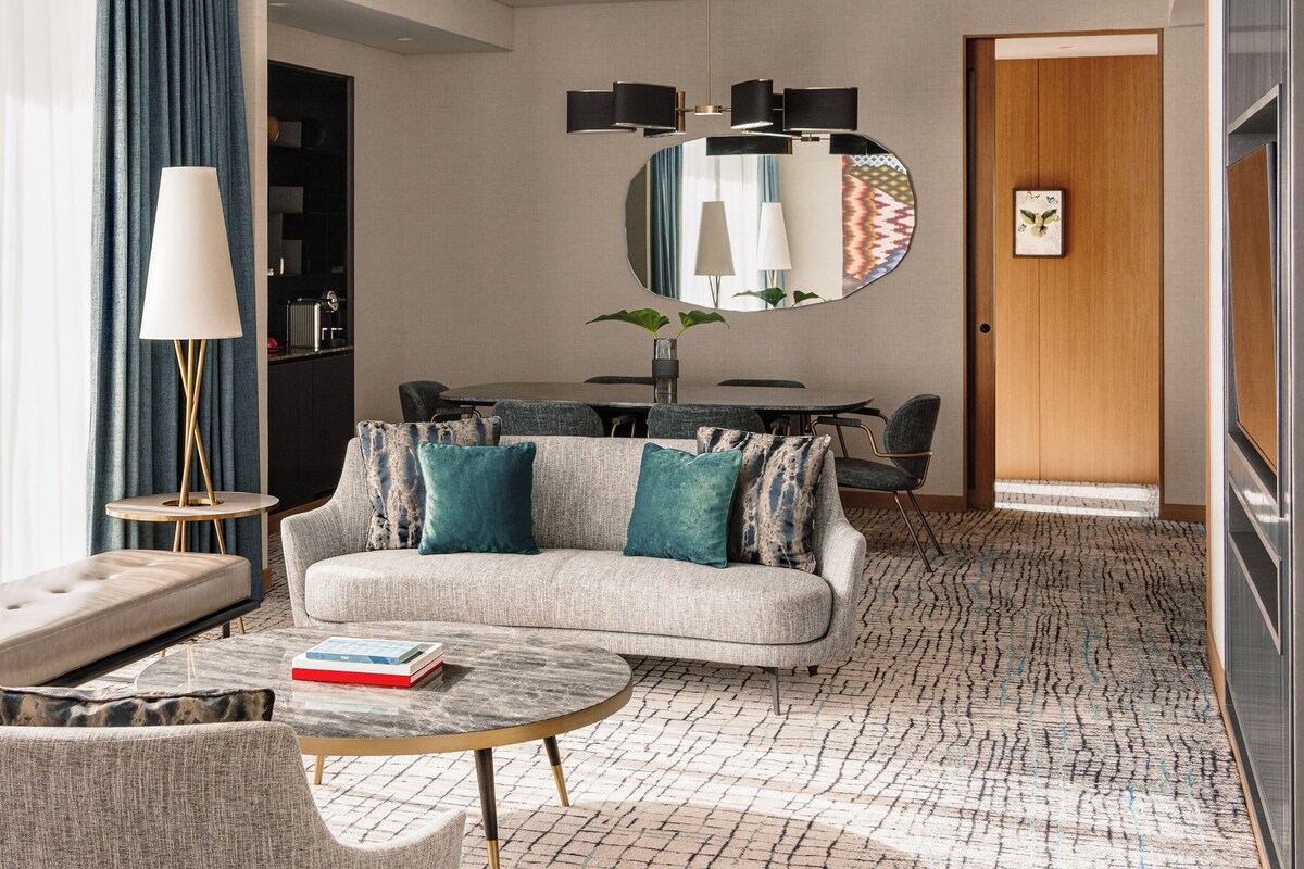 Une chambre d’hôtel moderne avec un canapé, une table basse et un coin repas.