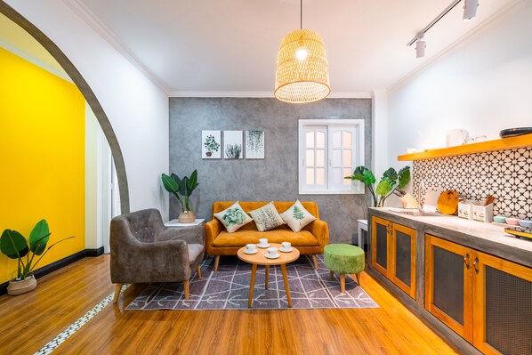 A modern living room with a sofa, coffee table, and plants.