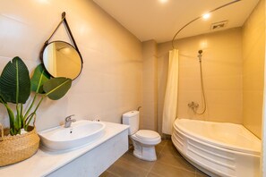 A bathroom with a sink, toilet, and bathtub.