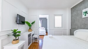 A hotel room with a bed, a desk, a television, and a window. - Chin Stays - Hotel and Apartment (Da Nang)