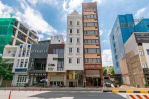 A multi-story building with a Star Beef restaurant on the ground floor, a makeup studio, and a hotel named Tulip.