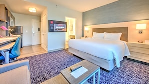 A hotel room with a bed, desk, chair, and a television. - TownePlace Suites by Marriott Port St. Lucie I-95 (Port Saint Lucie)
