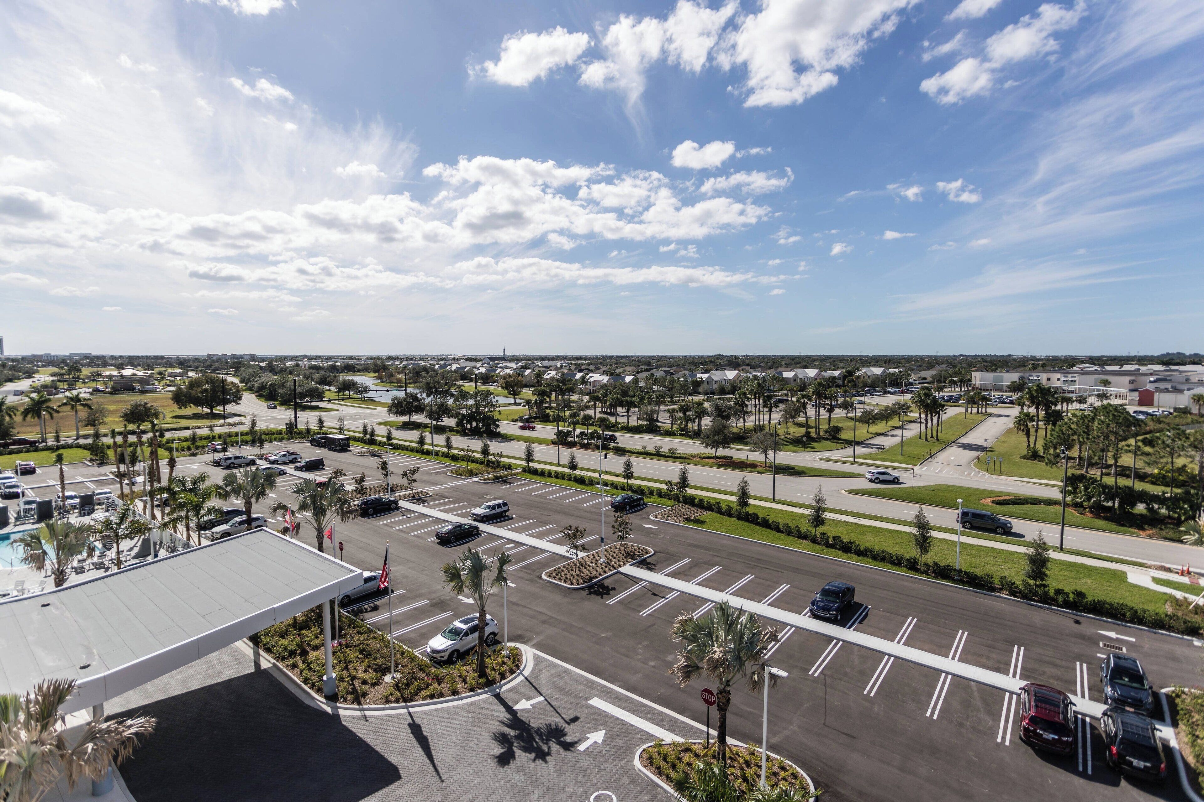 An aerial view of a parking lot with multiple lanes and a few cars parked.