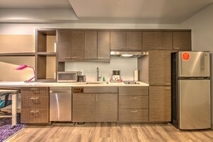 A modern kitchen with wooden cabinets, stainless steel appliances, and a built-in dishwasher.