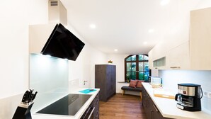 A modern kitchen with a built-in stove, a coffee maker, and a large window. - Vacation in the Harz Mountains the special *****Holiday apartments Burgkaiser im Zwinger Goslar (Goslar)