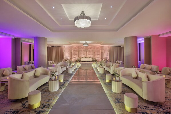 A spacious hotel room with a large bed, multiple seating areas, and a chandelier. - voco Al Khobar by IHG (Al Khobar)