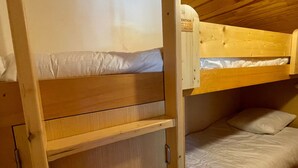 A bunk bed room with a wooden ceiling and a shelf unit. - Renovated 2-room apartment, 5 people, Méribel Altiport, ski-in/ski-out (Méribel)