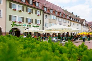 A hotel with outdoor seating and a fountain.