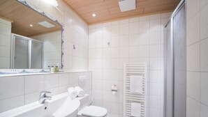 A modern bathroom with a sink, toilet, and shower area. - Hotel Gasthof Jägerstüble (Freudenstadt)
