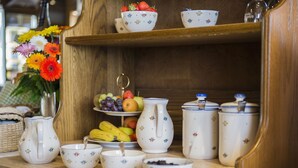 A wooden shelf with various kitchenware, including a pitcher, bowls, and a fruit stand. - Hotel Gasthof Jägerstüble (Freudenstadt)