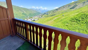 Un balcon donnant sur une vallée et des montagnes.