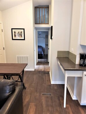 Una cocina compacta con una mesa de comedor, una cafetera y una pequeña área de preparacion.