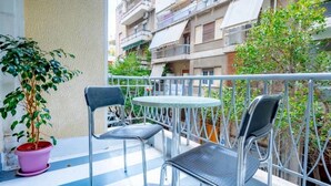 A balcony with two metal chairs and a small round table, surrounded by a metal railing. - S&K Polyxene Suite in Center of Athens (Athens)