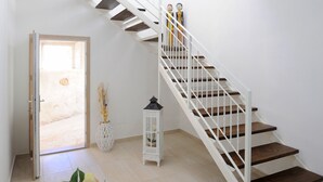 A staircase with white railings and wooden steps leading to an upper floor. - INAH Boutique Rooms (Dorgali)