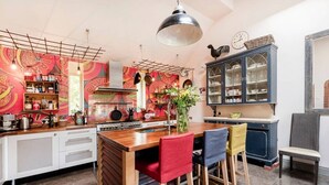 A kitchen with a central island, white cabinets, and a decorative backsplash. - Characterful Home in beautiful surroundings of Surrey Hills (Bramley)
