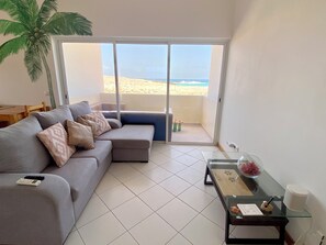 Departamento Confort, 2 habitaciones, vista al océano, frente al mar | Área de sala de estar | Smart TV de 100 pulgadas con canales digitales, Netflix y libros 