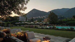 Ein Außenbereich mit Sitzgelegenheiten, einem Pool und Bergen im Hintergrund.
