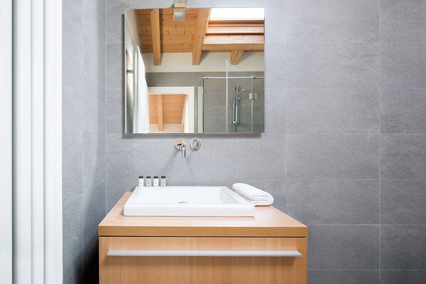 A bathroom with a wooden vanity, a white sink, and a mirror above it. - KK Resort Apartments Lake Como (Como)