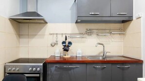 Eine kleine Küche mit Herd, Backofen und Spüle.
