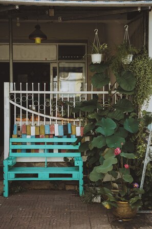 A wooden bench with colorful blocks, a white fence, and various potted plants.