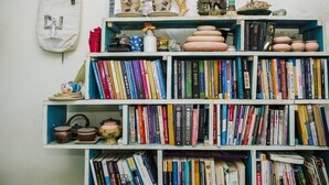 A bookshelf filled with books and decorative items. - Bui Homestay - Rach Gia Ferry Terminal (Rach Gia)