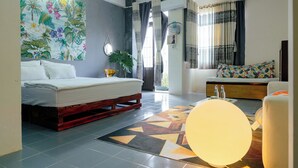 A modern bedroom with a bed, a sofa, a large window with curtains, a wall-mounted fan, and a ceiling projector. - Bui Homestay - Rach Gia Ferry Terminal (Rach Gia)