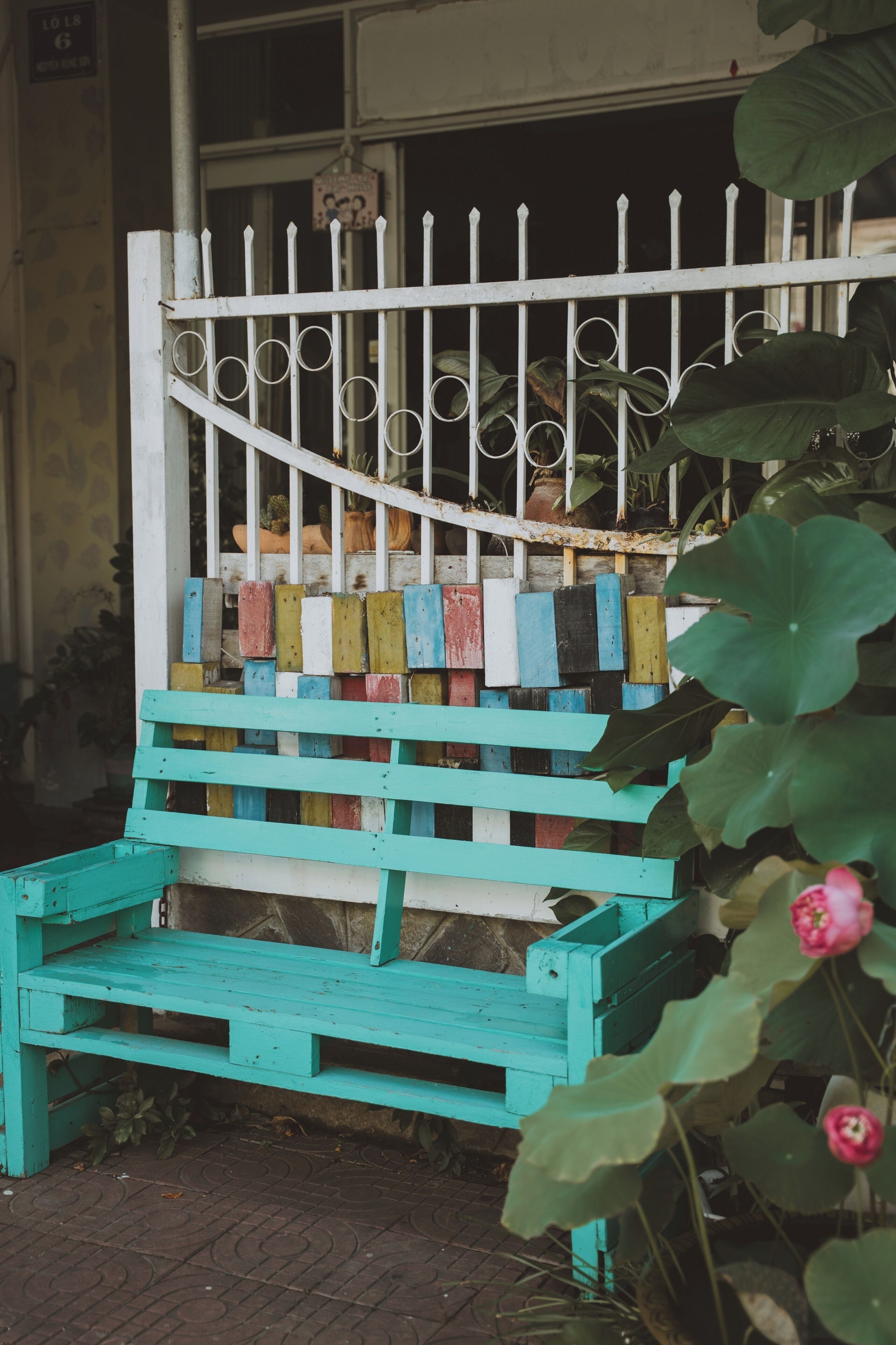 A wooden bench with a white metal fence in the background.