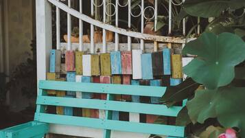 A wooden bench with a white metal fence in the background.