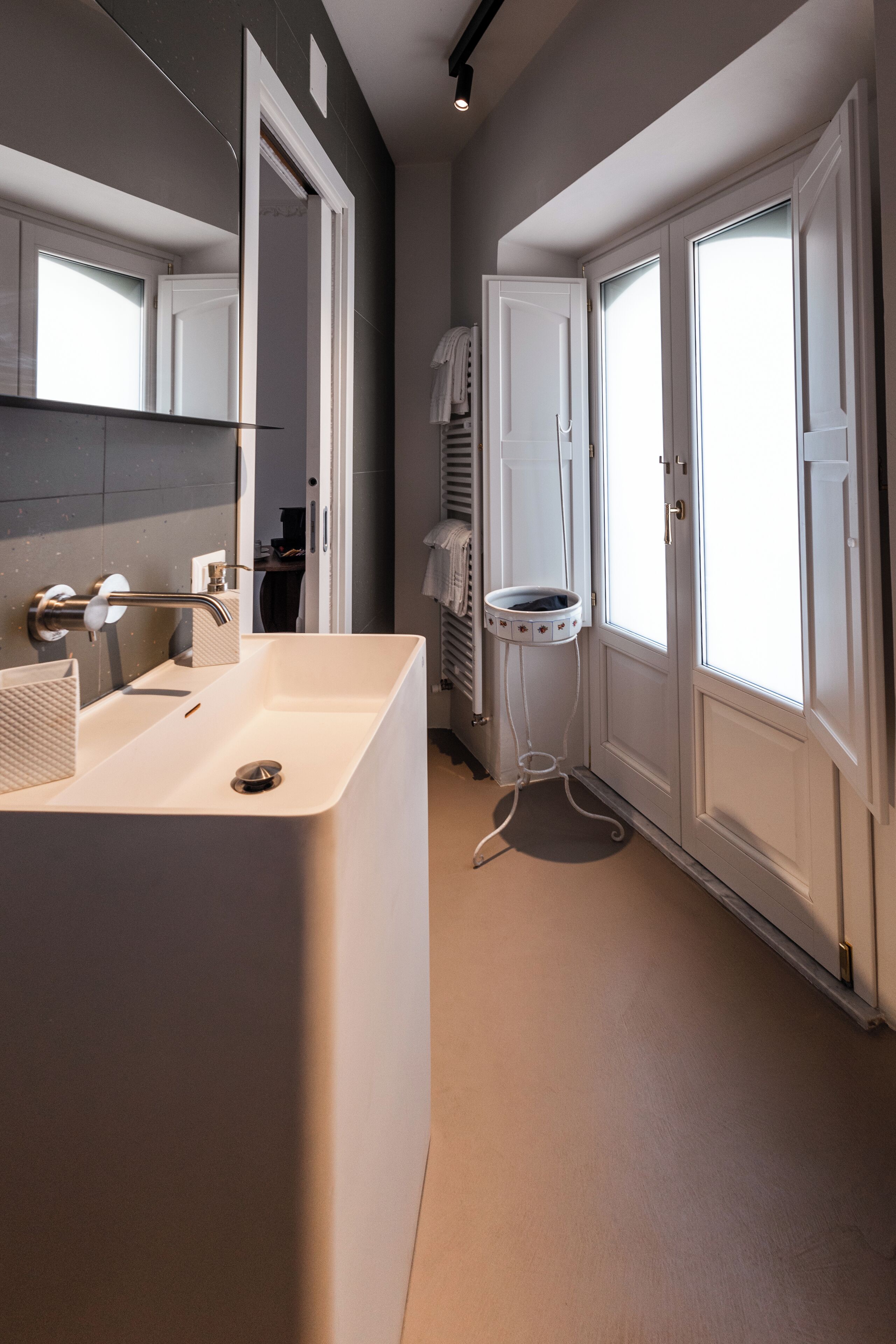 Ein modernes Badezimmer mit einem großen Waschbecken, einem Spiegel und einer Toilette.