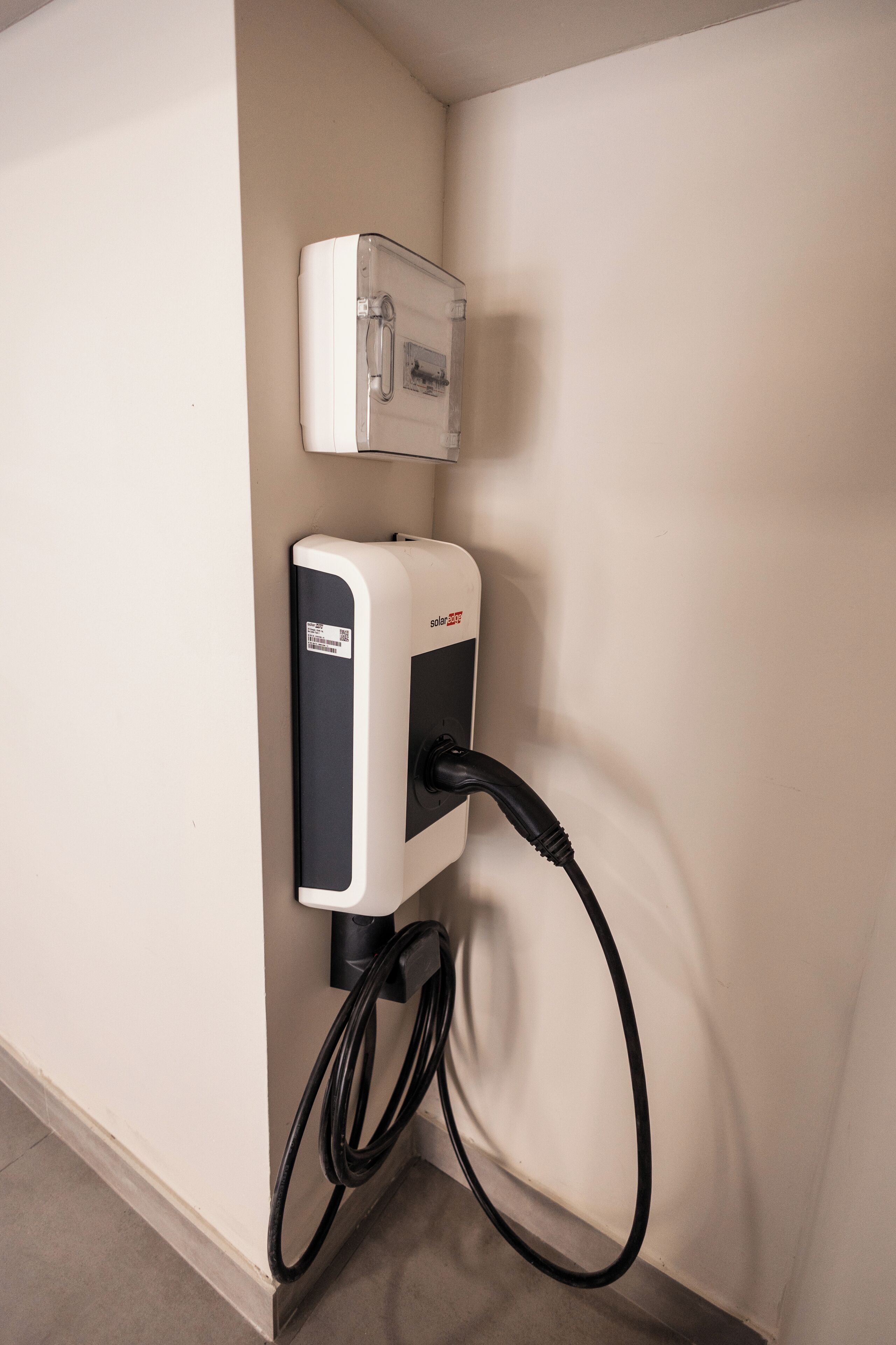 Carregador de painel solar fixado na parede, com um cabo conectado.
