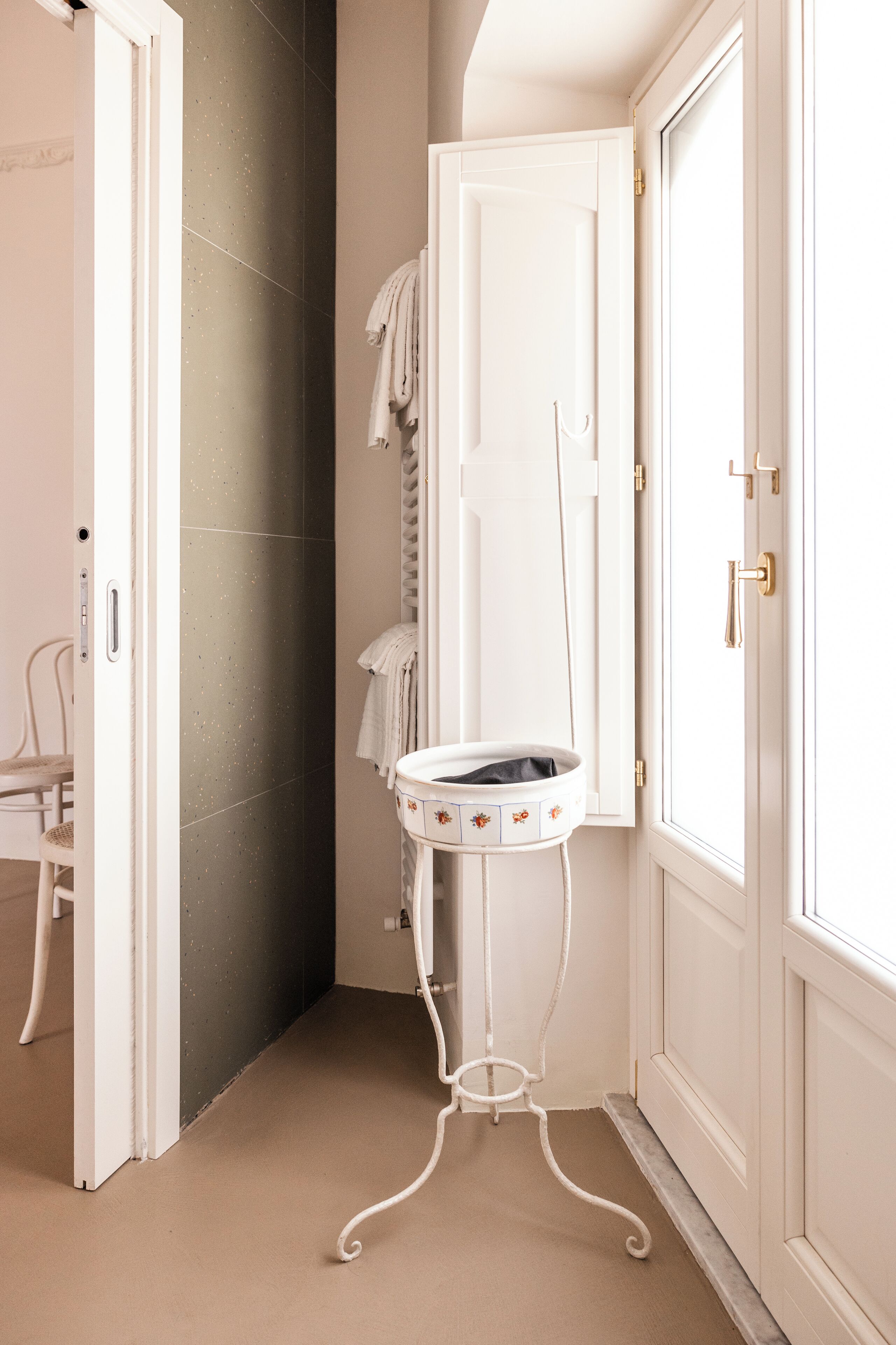 Une salle de bain avec un meuble-lavabo blanc, un porte-serviettes et une porte.