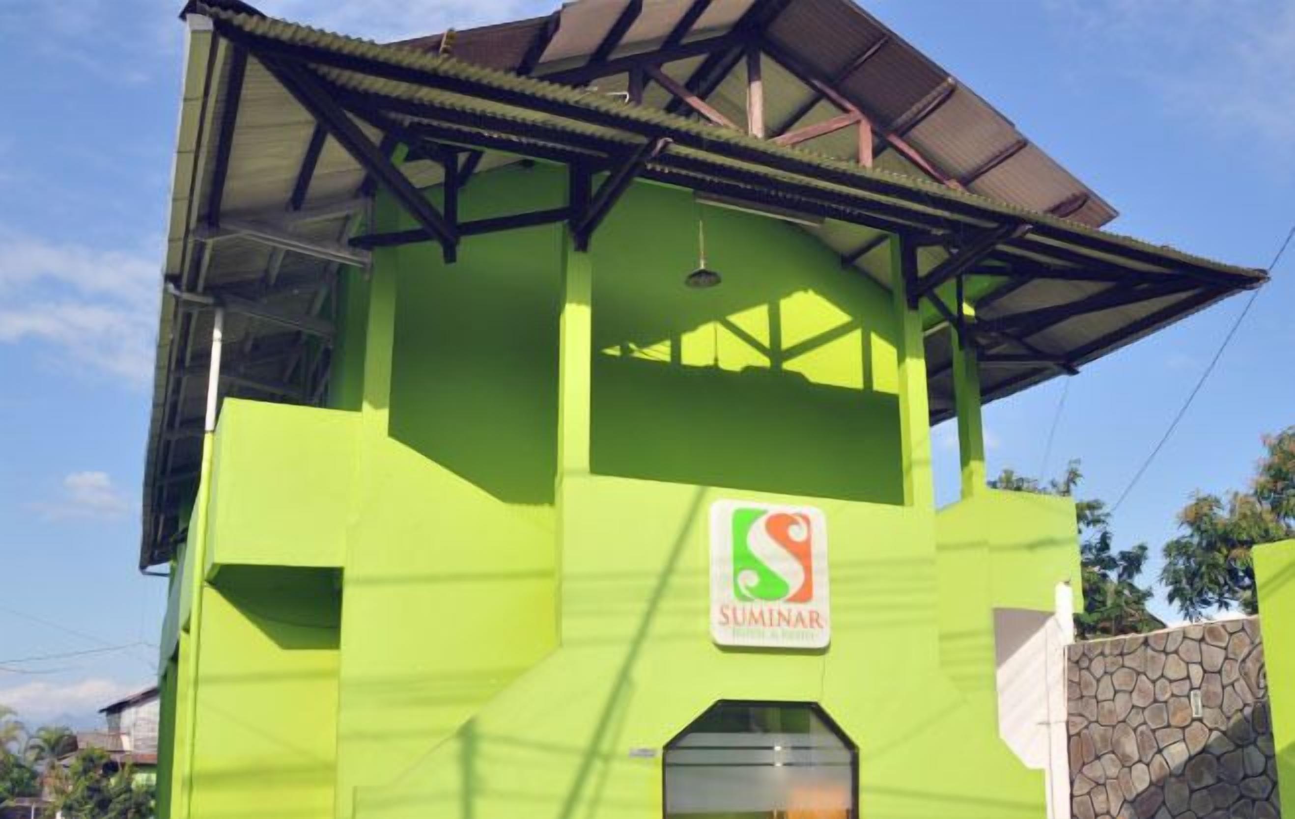 Un edificio verde con un letrero que dice "SUMINAR".