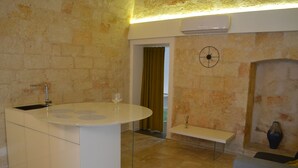 Una cocina moderna con una isla central, un lavamanos empotrado y una pared de piedra.