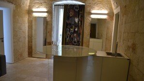 Un baño con lavamanos con puerta de vidrio, un espejo y zona de ducha.
