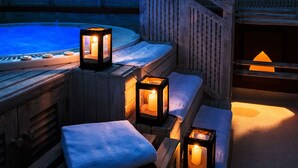 A hot tub area with wooden benches and lanterns providing ambient lighting. - Medina Palms (Watamu)