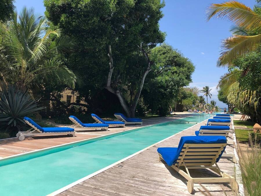 A poolside area with lounge chairs and a wooden deck.