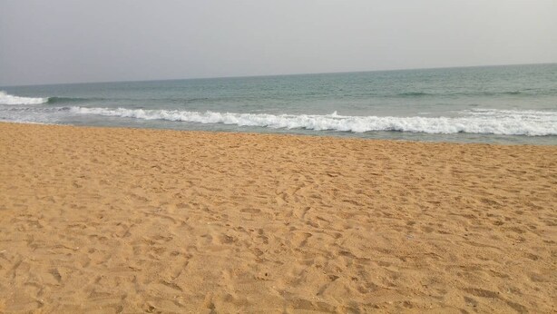 Una playa con arena y olas.