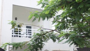 Un edificio blanco con un balcón y una ventana.