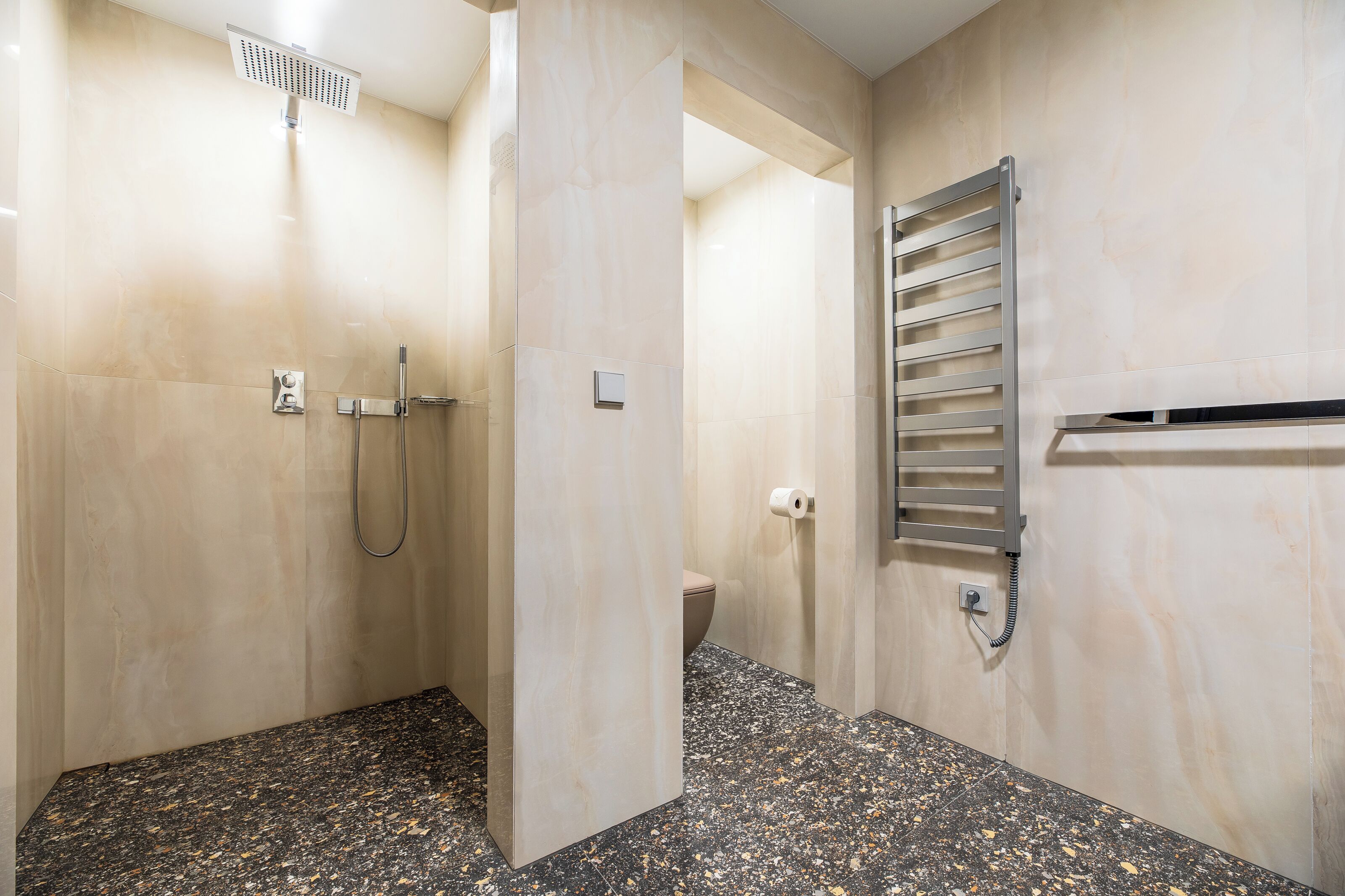 Un bagno moderno con doccia, WC e porta asciugamani.
