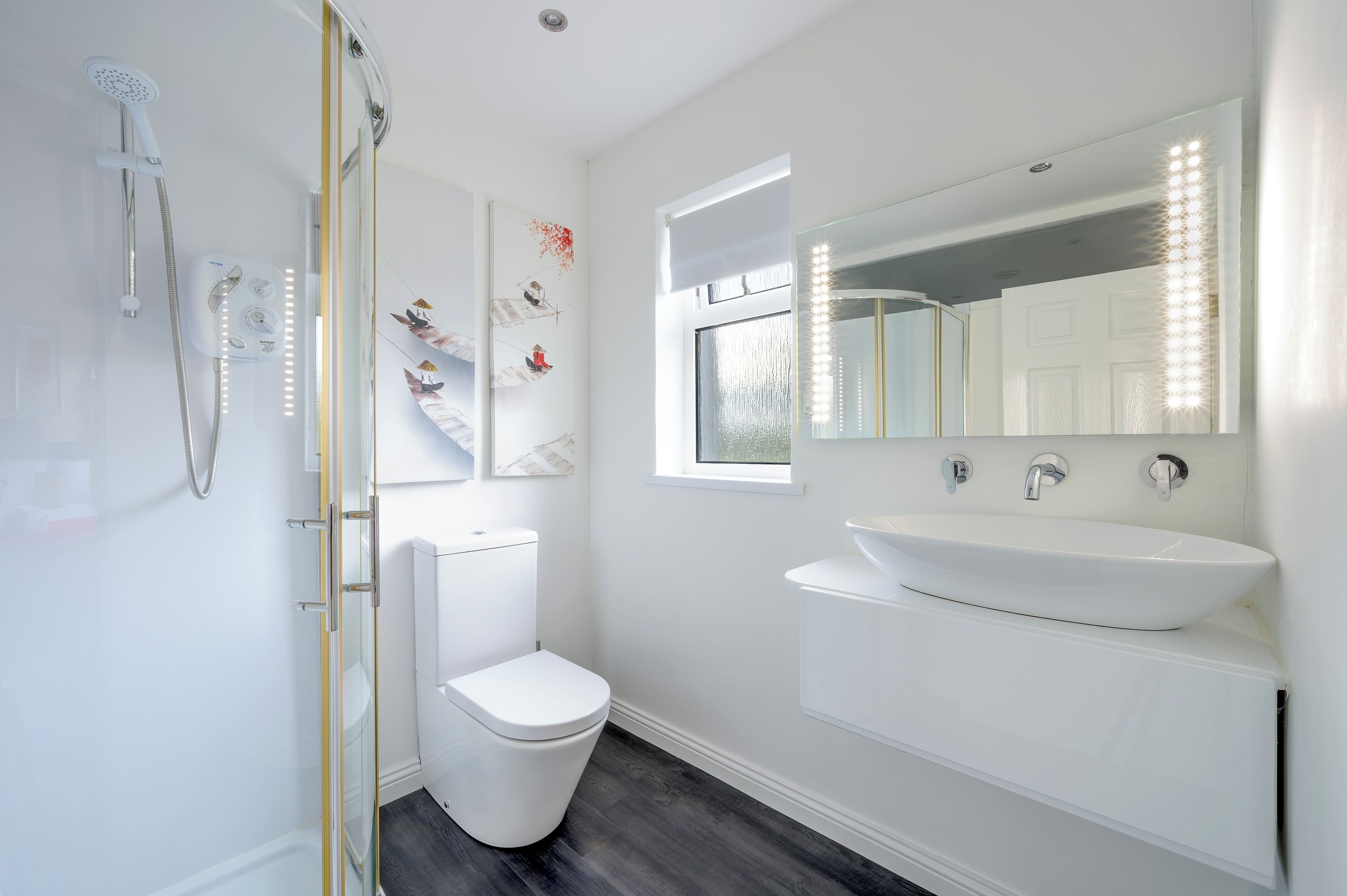 A modern bathroom with a shower, toilet, and vanity.