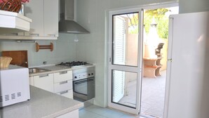 A kitchen with white cabinets, a gas stove, an oven, and a refrigerator. - Stylish and well-equipped, private pool, close to amenities, free AC & Wifi (Vilamoura)