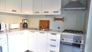 A modern kitchen with white cabinets, a dishwasher, a coffee maker, a stove, and a built-in oven. - Stylish and well-equipped, private pool, close to amenities, free AC & Wifi (Vilamoura)