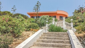Ein gebogenes Gebäude mit einer Treppe, die zu einem weißen Geländer führt.