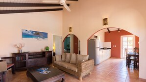 Un amplio salón con sofá, mesa de centro y comedor con mesa y sillas.