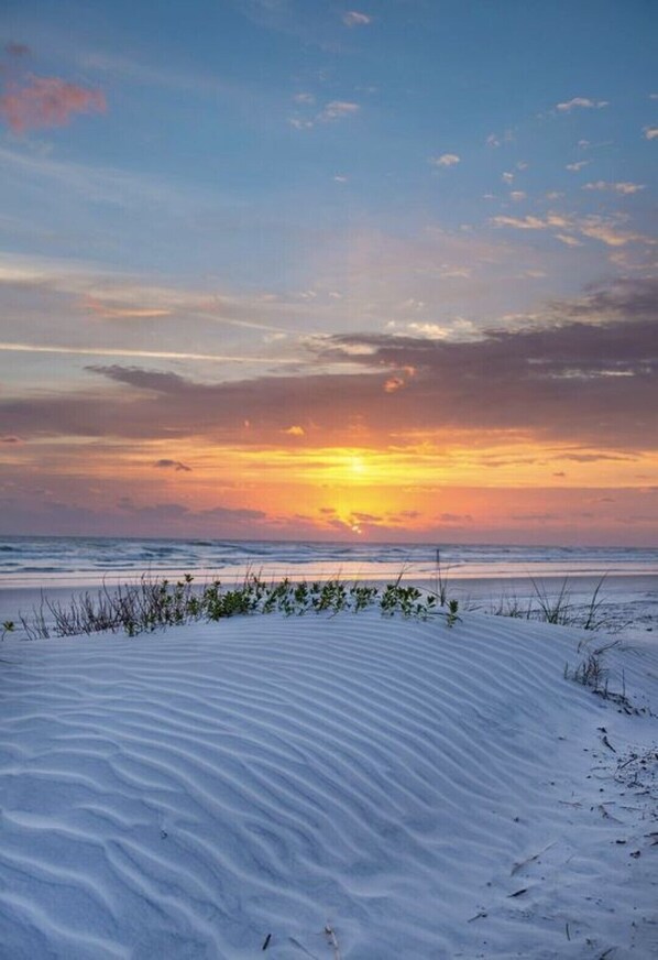 Rannalla, aurinkotuoleja, rantapyyhkeitä