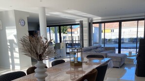 Un espace de restauration moderne, avec une longue table, des chaises et un élément décoratif central.