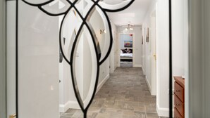 A hallway with a patterned floor, white walls, and a bed in the distance. - Cottage 345 - Oughterard  - sleeps 10 guests  in 4 bedrooms (Oughterard)