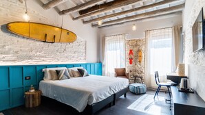 Ein Schlafzimmer mit einem Bett, einem Surfbrett, einem Schreibtisch und einem Stuhl.